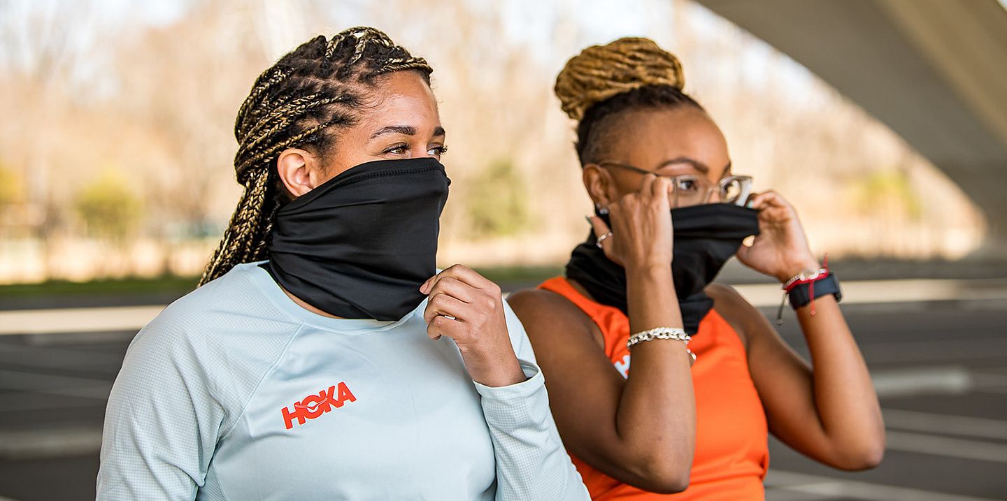 Dos mujeres con máscaras se preparan para correr