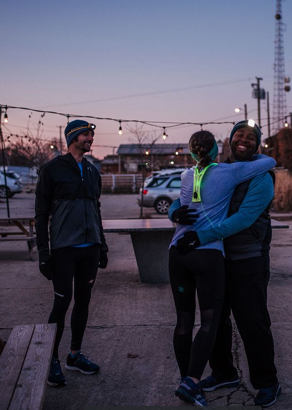 Tres corredores se preparan para hacer ejercicio por la noche